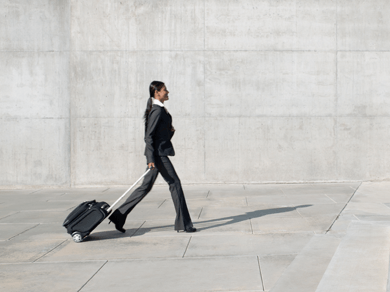 A woman traveling with a suitcase, representing WTS Global’s global mobility services